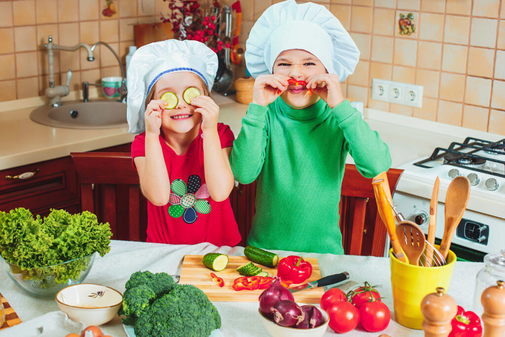 Kinder mit Gemüse und Obst in der Küche